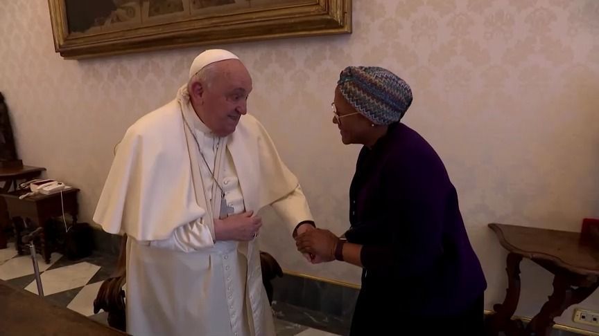 Com braço imobilizado após queda, Papa Francisco cumprimenta pessoas no Vaticano.