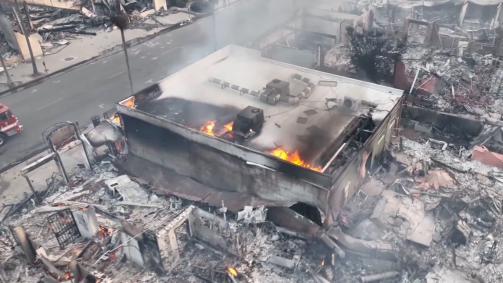 Drone mostra edifícios de Los Angeles em cinzas devido a incêndios florestais.