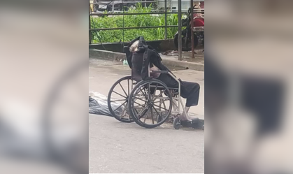 Homem carrega corpo de idosa morta em cadeira de rodas por ruas do RJ
