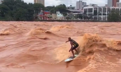 Surfista faz manobras em cheia de rio
