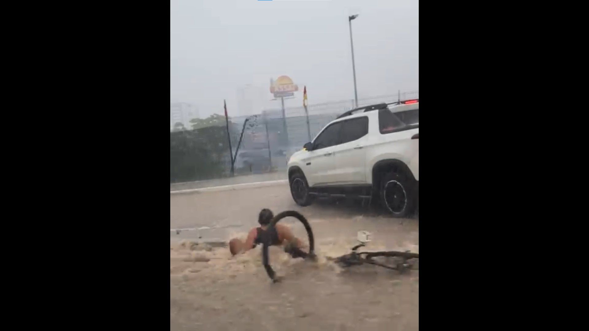 Momento em que o ciclista é arrastado pela correnteza