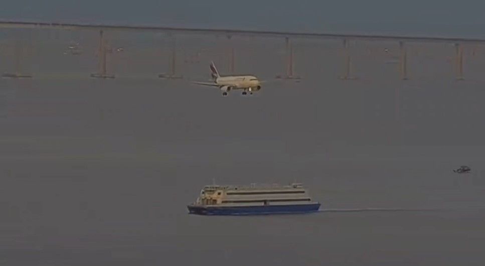 Momento em que o avião da Latam se aproxima de embarcação durante pouso no Santos Dumont, no Rio de Janeiro