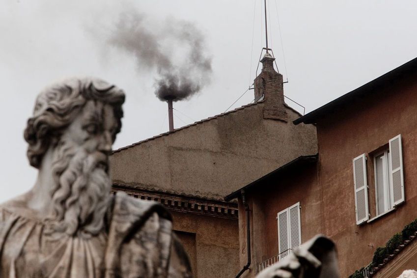 Fumaça preta sai de uma chaminé no telhado da Capela Sistina, indicando que o Colégio dos Cardeais falhou em eleger um novo Papa em março, durante o segundo dia do Conclave, no Vaticano. • Alessandra Benedetti/Corbis via Getty Images