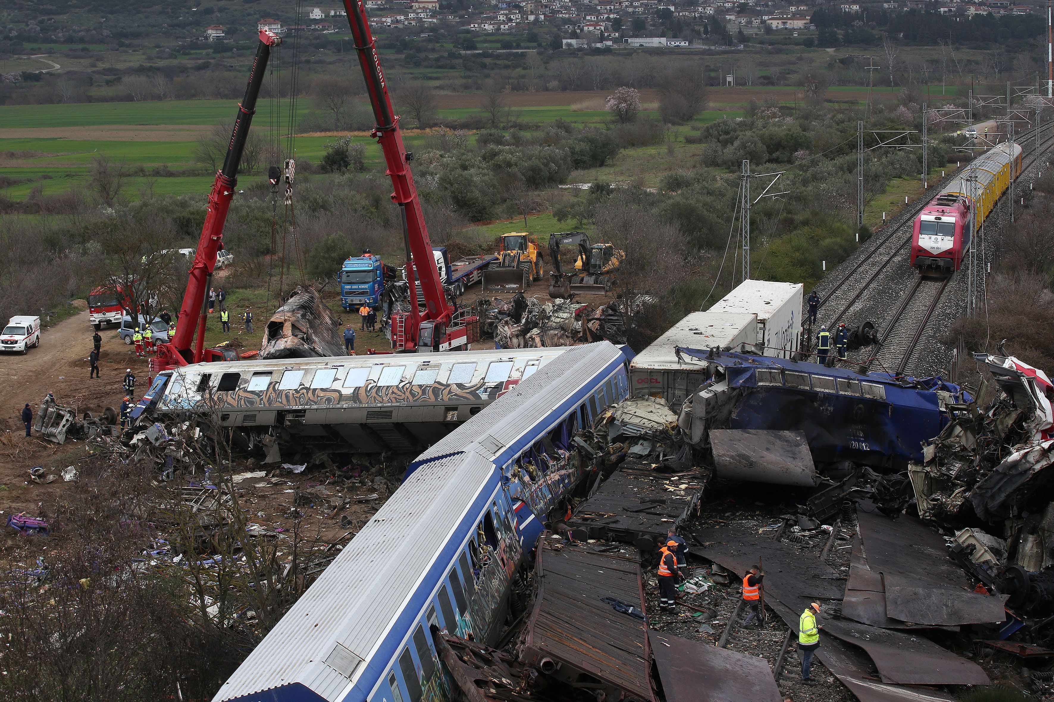 Equipes de resgate e bombeiros operam próximo aos destroços de um trem, após uma colisão entre dois trens, em 2023, na Grécia.