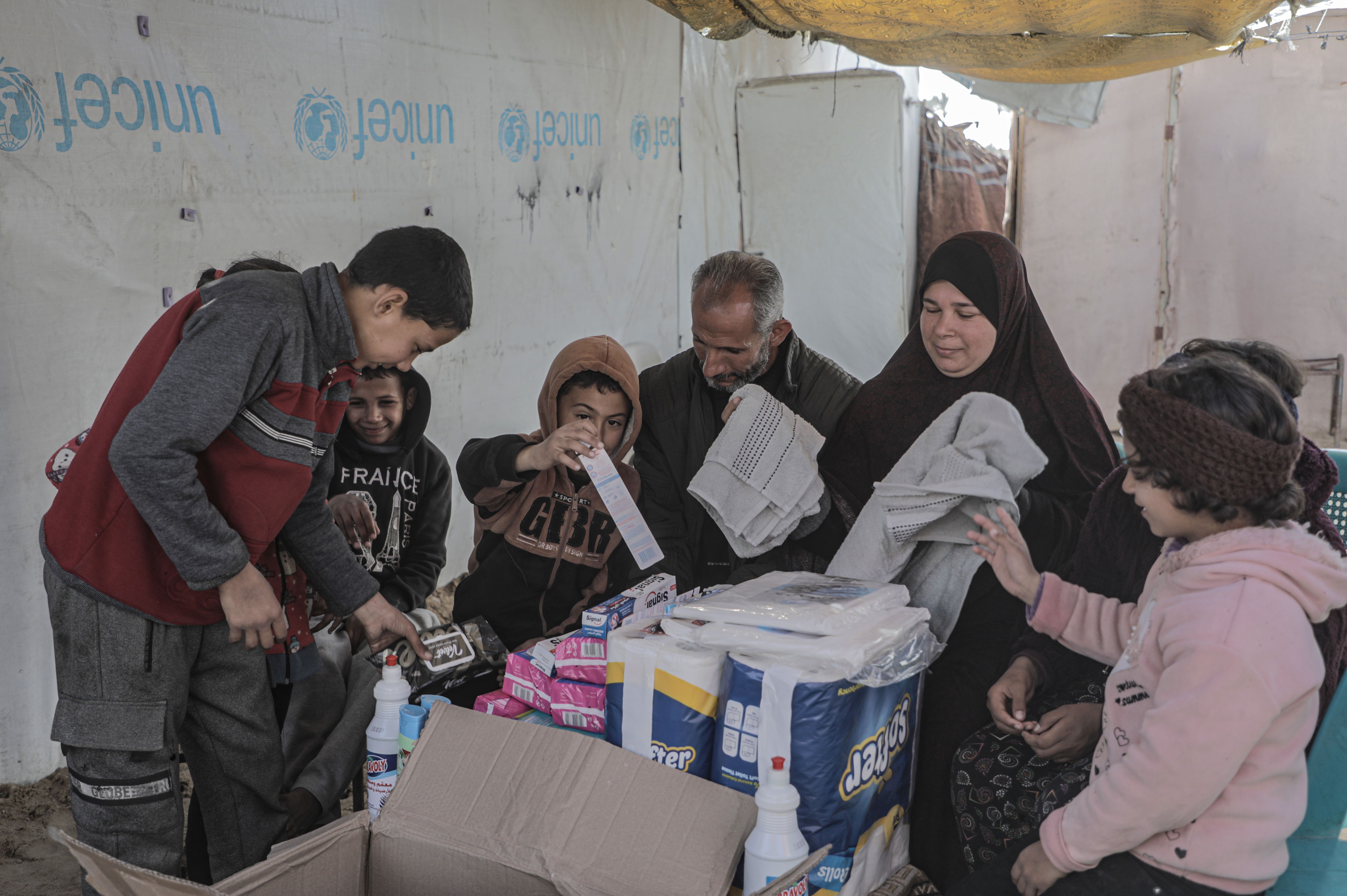 Em 23 de janeiro de 2025, família recebe kits de higiene distribuídos para famílias em Khan Younis, no centro de Gaza. • UNICEF
