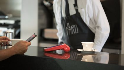 Consumidor utiliza o celular para realizar pagamento em maquininha da Getnet