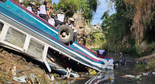 Bombeiros tentam resgatar uma pessoa após ônibus cair de ponte na Guatemala