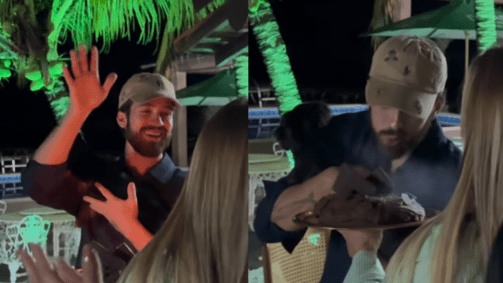 Com um cachorro no colo, João Guilherme cantou parabéns enquanto sua irmã segurava um bolo com a vela acesa