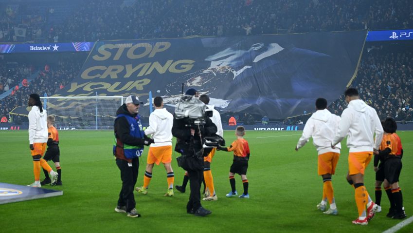 Real Madrid entra em campo no Etihad Stadium enquanto a torcida do Manchester City exibe bandeirão provocando Vini Jr • Michael Regan/Getty Images