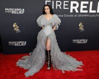 Charli XCX uniu um corpete clássico com mangas e uma saia de babados cinzas, combinando com uma bota preta até os joelhos
