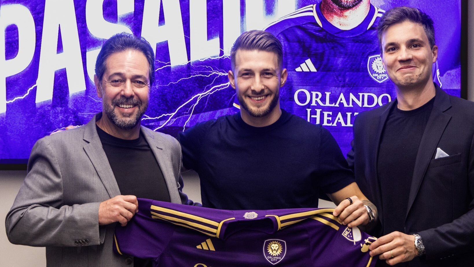 Marco Pasalic sendo anunciado pelo Orlando City segurando a camisa da equipe