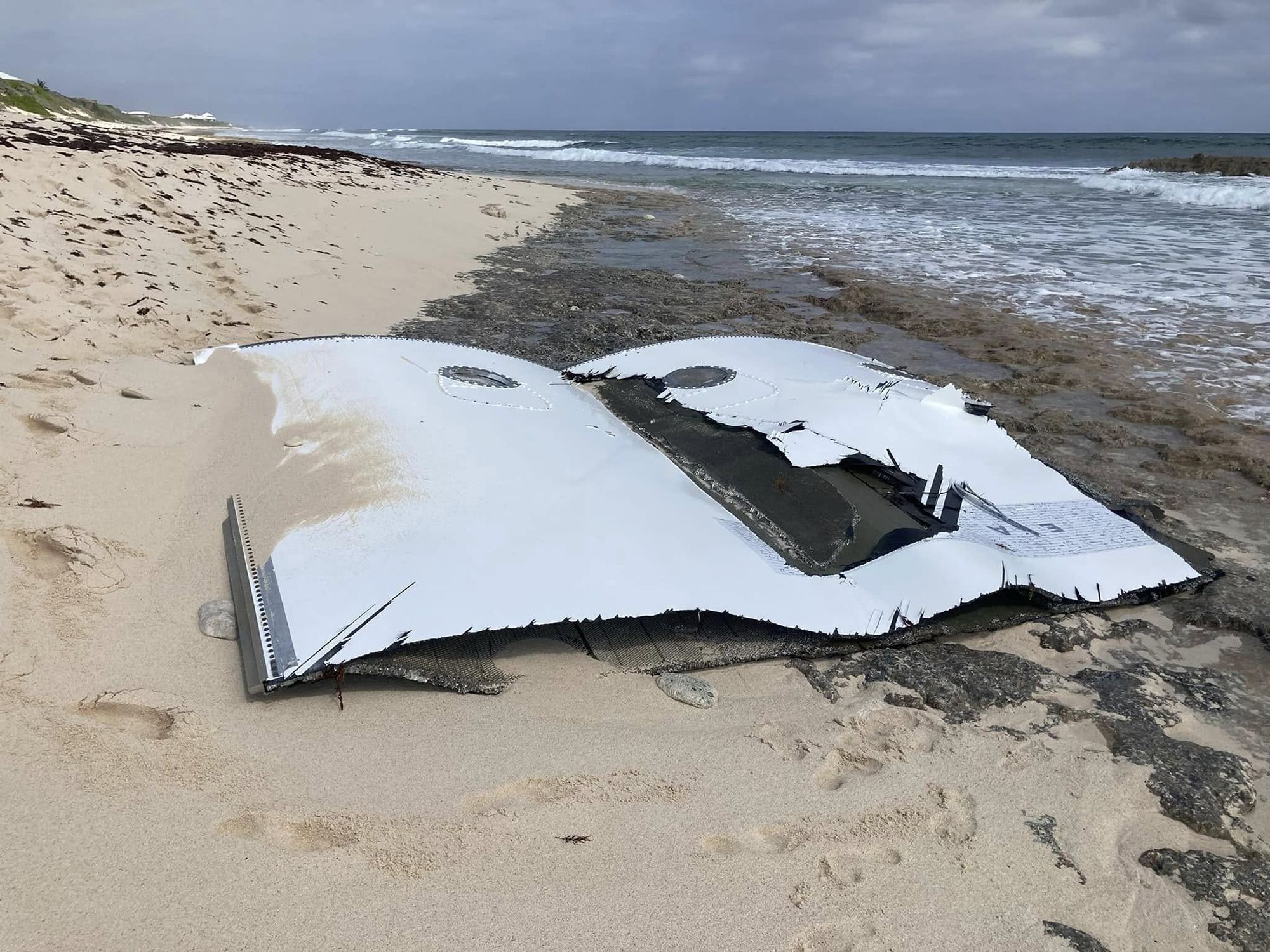 Os destroços da carenagem da carga útil, ou cone do nariz, do foguetão New Glenn da Blue Origin aparecem numa praia das Bahamas depois de terem dado à costa • Judy Fortenberry via CNN Newsource