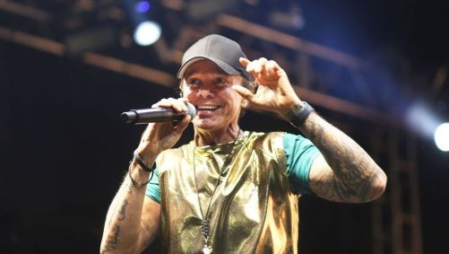 Cantor Netinho durante show. Ele usa um boné
