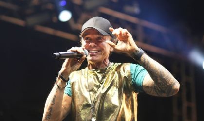 Cantor Netinho durante show. Ele usa um boné