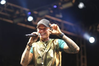 Cantor Netinho durante show. Ele usa um boné