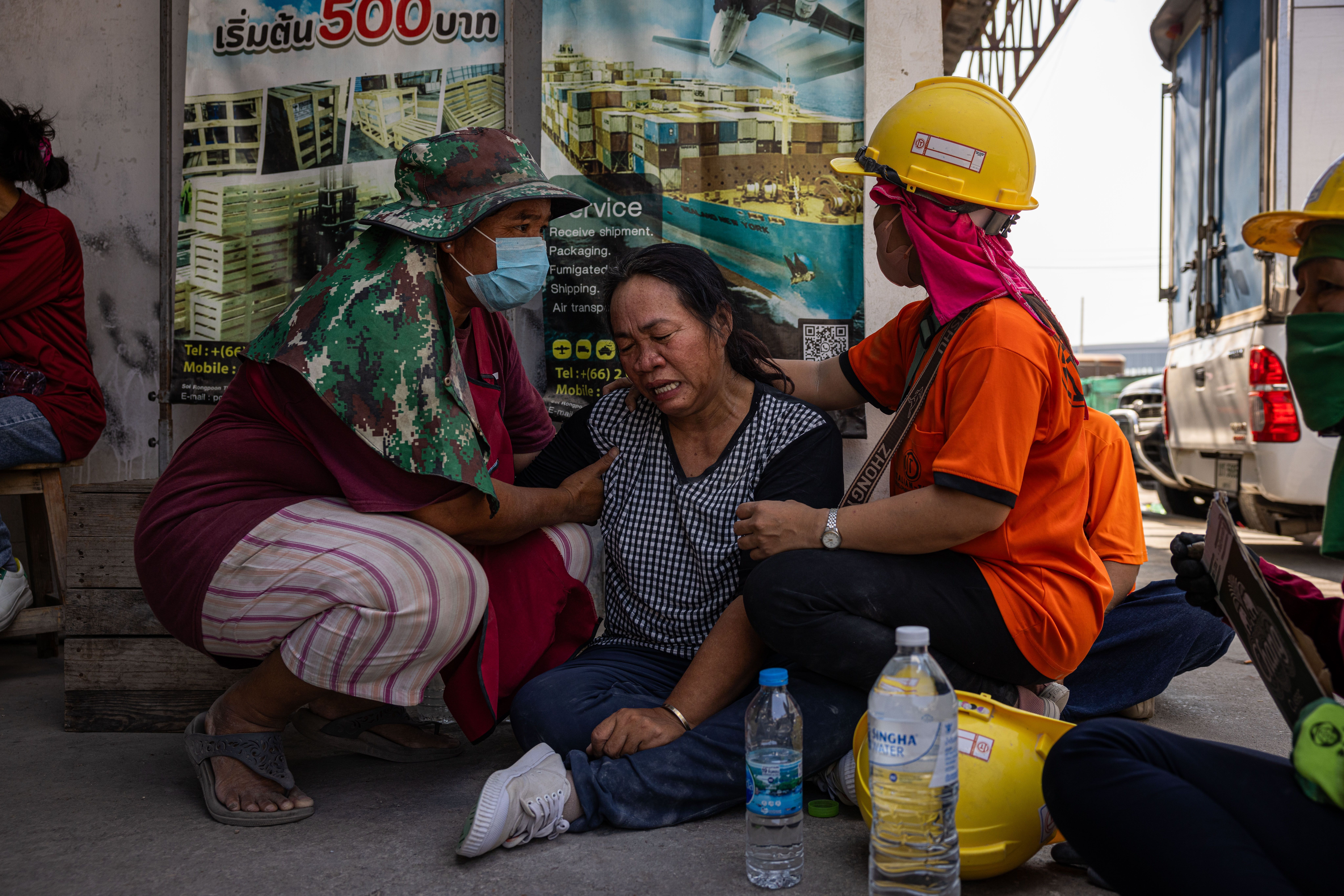 Pessoas choram ao lado de um prédio desabado perto do Mercado Chatuchak após um terremoto em 28 de março de 2025 em Bangkok, Tailândia. Um poderoso terremoto de magnitude 7,7 atingiu Mianmar em 28 de março de 2025, causando fortes tremores sentidos em Bangkok, onde os prédios balançaram. • Lauren DeCicca/Getty Images