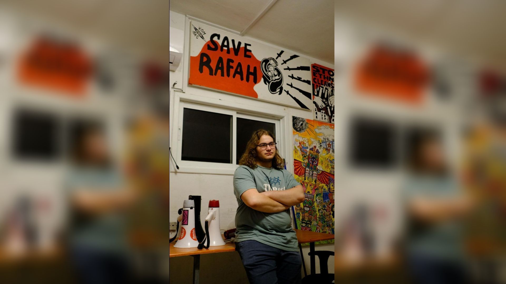 Itamar Greenberg está sob uma pintura que diz “Salve Rafah” na sede da coalizão política de esquerda Hadash em 22 de março. • Kara Fox/CNN via CNN Newsource Dateline: Israel