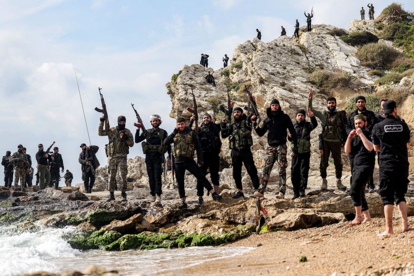 Integrantes das forças de segurança leais ao governo interino sírio posam para uma foto na costa do Mar Mediterrâneo em Latakia, em 9 de março. • Omar Haj Kadour/AFP via Getty Images via CNN Newsource