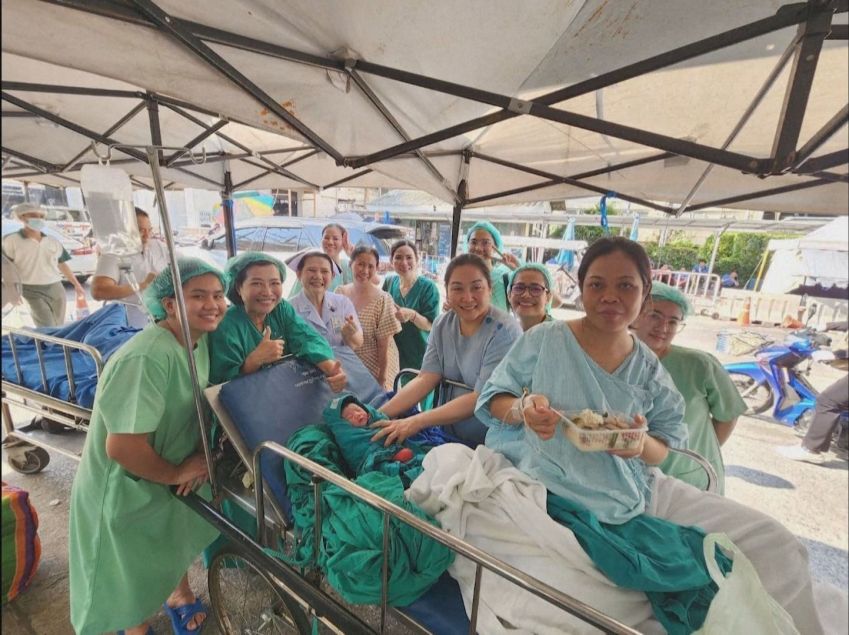 Mulher tailandesa que deu à luz durante terremoto na Tailândia, do lado de fora do hospital, ao lado do bebê e equipe médica em Bangkok. • Reprodução/Reuters