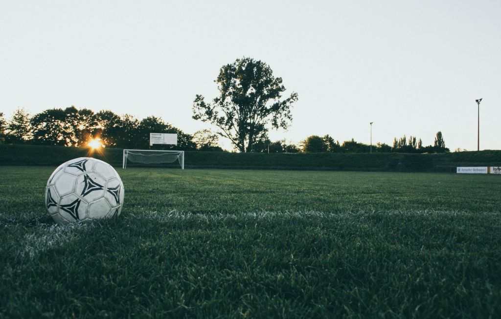 Bola em campo de futebol durante à tarde