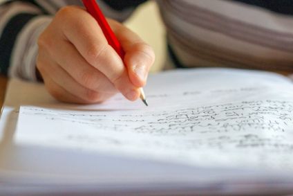 Estudante escrevendo no papel