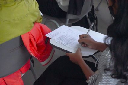 Estudante escrevendo em uma folha de papel