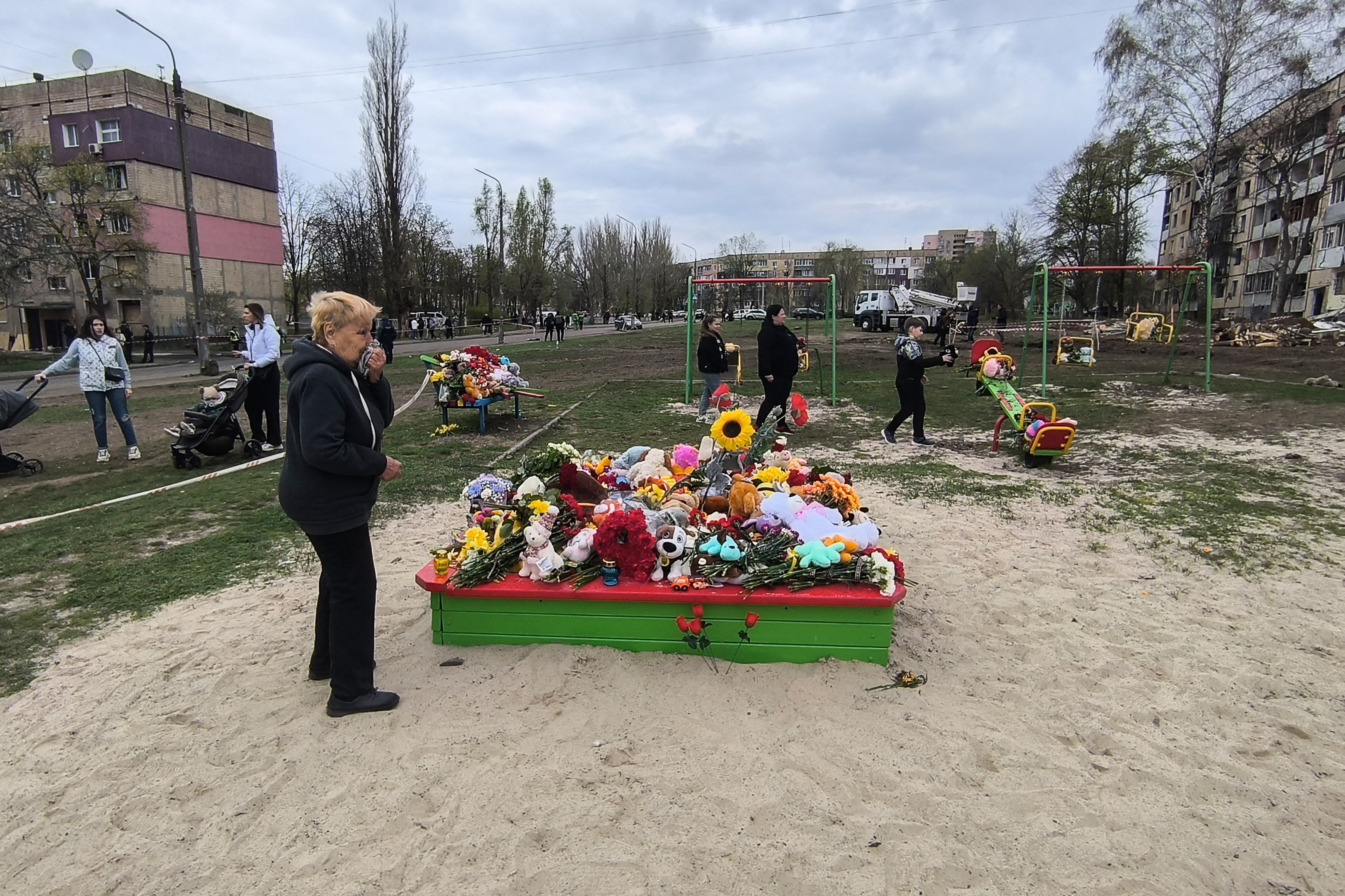 Pessoas deixam flores e brinquedos em um playground onde pessoas foram mortas após um ataque russo com míssil, em 5 de abril de 2025, em Kryvyi Rih, Ucrânia, cidade natal do presidente Volodymyr Zelensky.