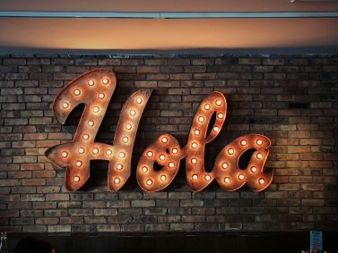 "Hola" escrito na parede. A palavra significa "olá" em português