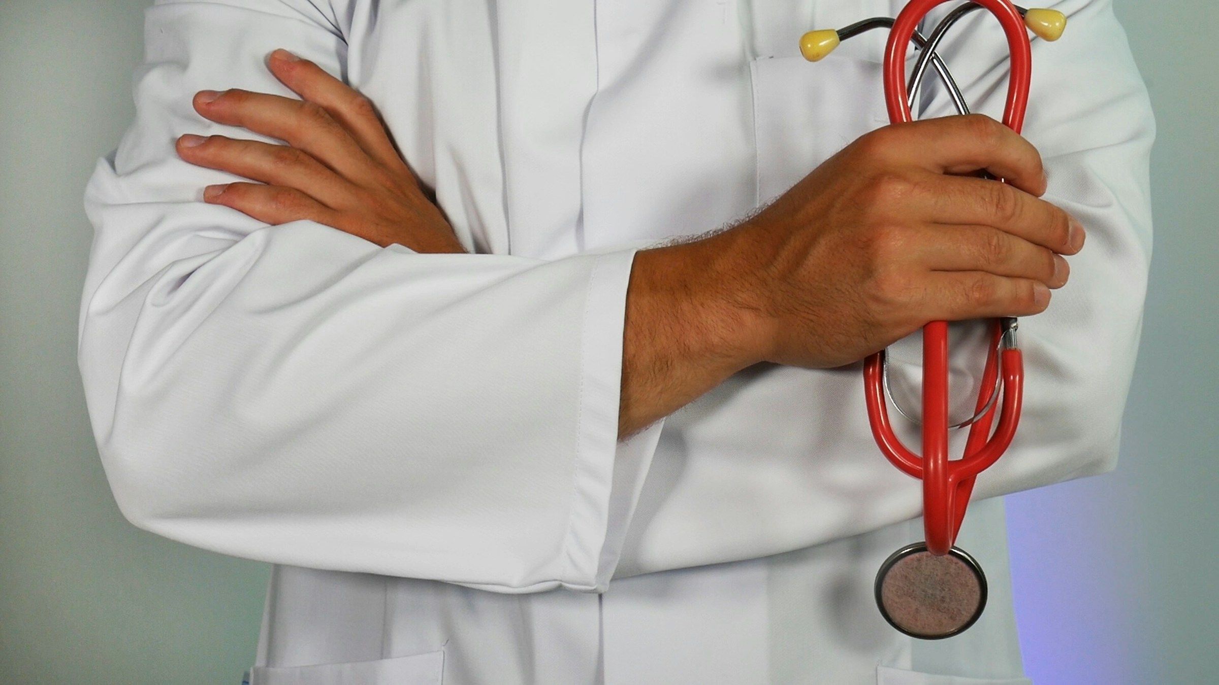 Médico. Ele está vestindo um jaleco