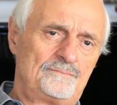 Foto do diretor Ted Kotcheff. Ele tem a pele branca. O cabelo e o bigode dele também são brancos