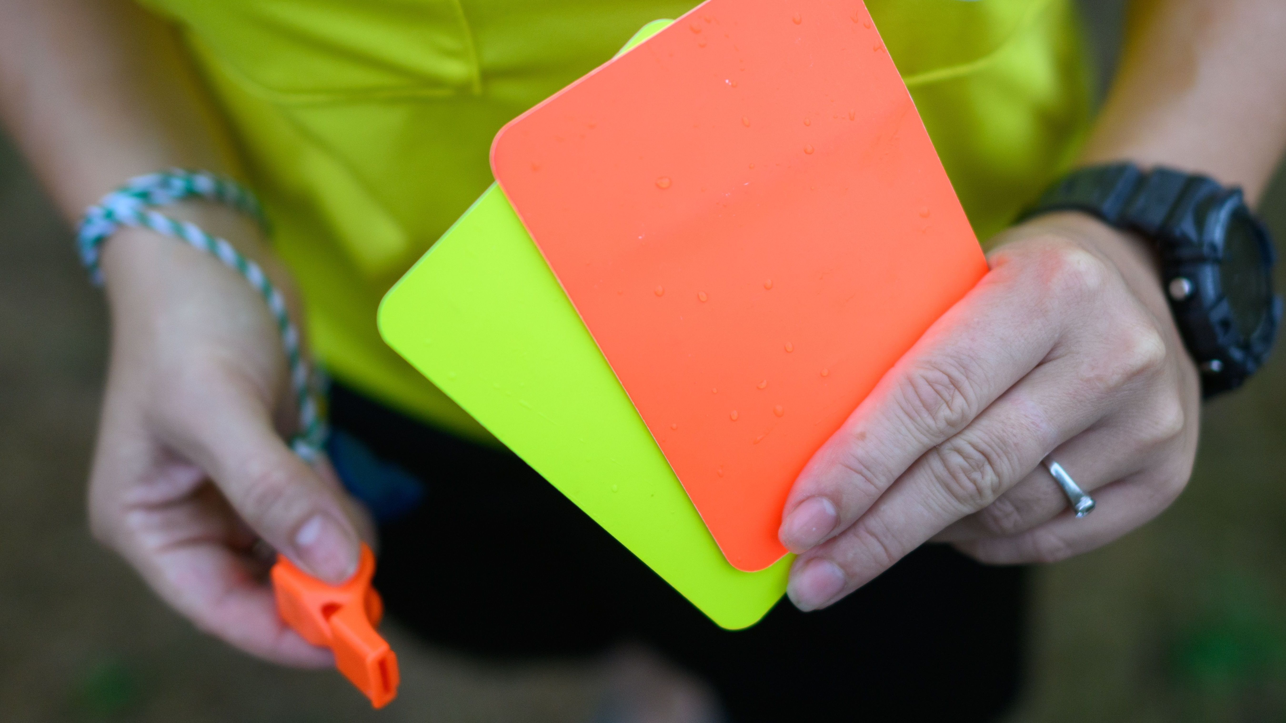 Cartões amarelo e vermelho na mão de árbitra