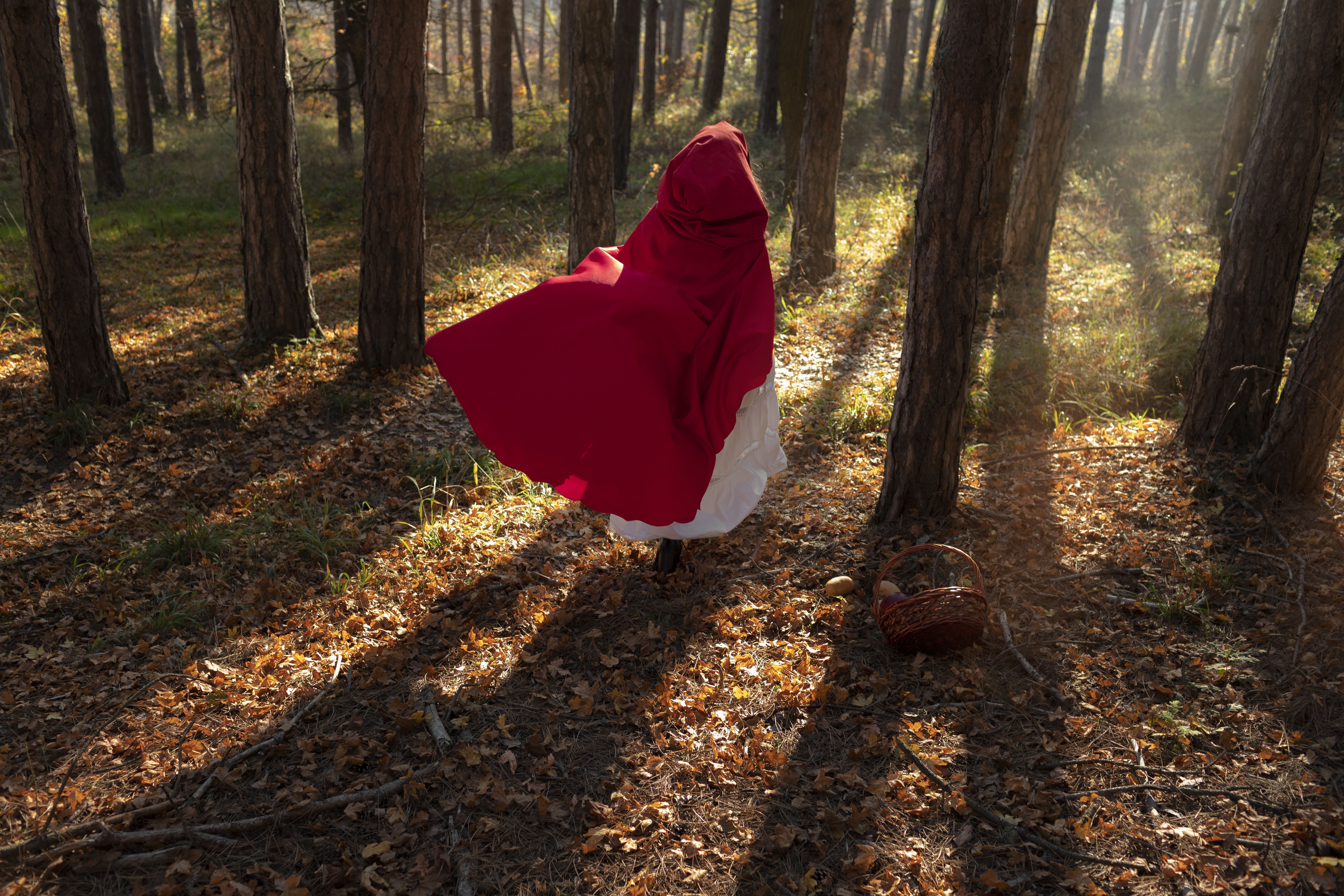 Mulher vestida de Chapeuzinho Vermelho na floresta