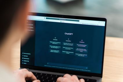 Visão próxima de um homem com um bate-papo de IA aberto no laptop