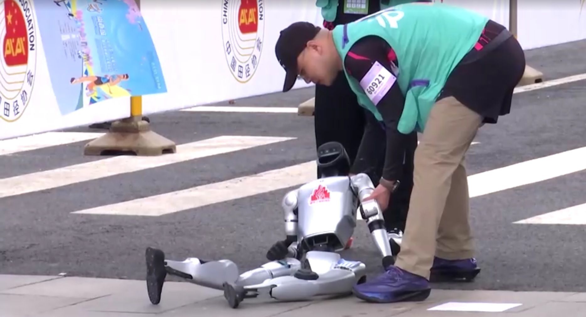 Robô caído na linha de largada da meia maratona na China • Reprodução/Reuters