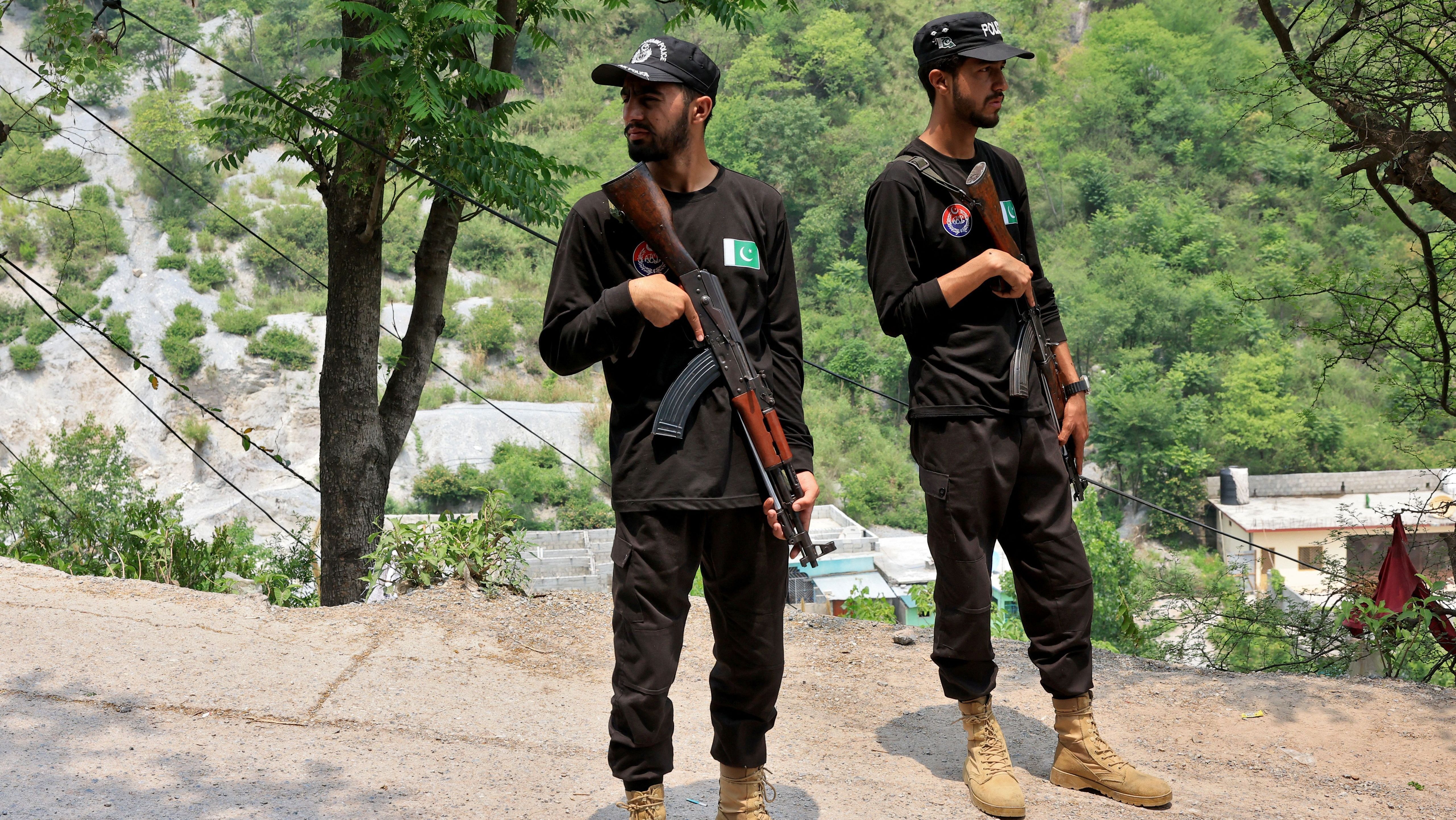 Policiais montam guarda em estrada que leva à Mesquita Bilal após ela ter sido atingida por ataque indiano em Muzaffarabad, no Paquistão