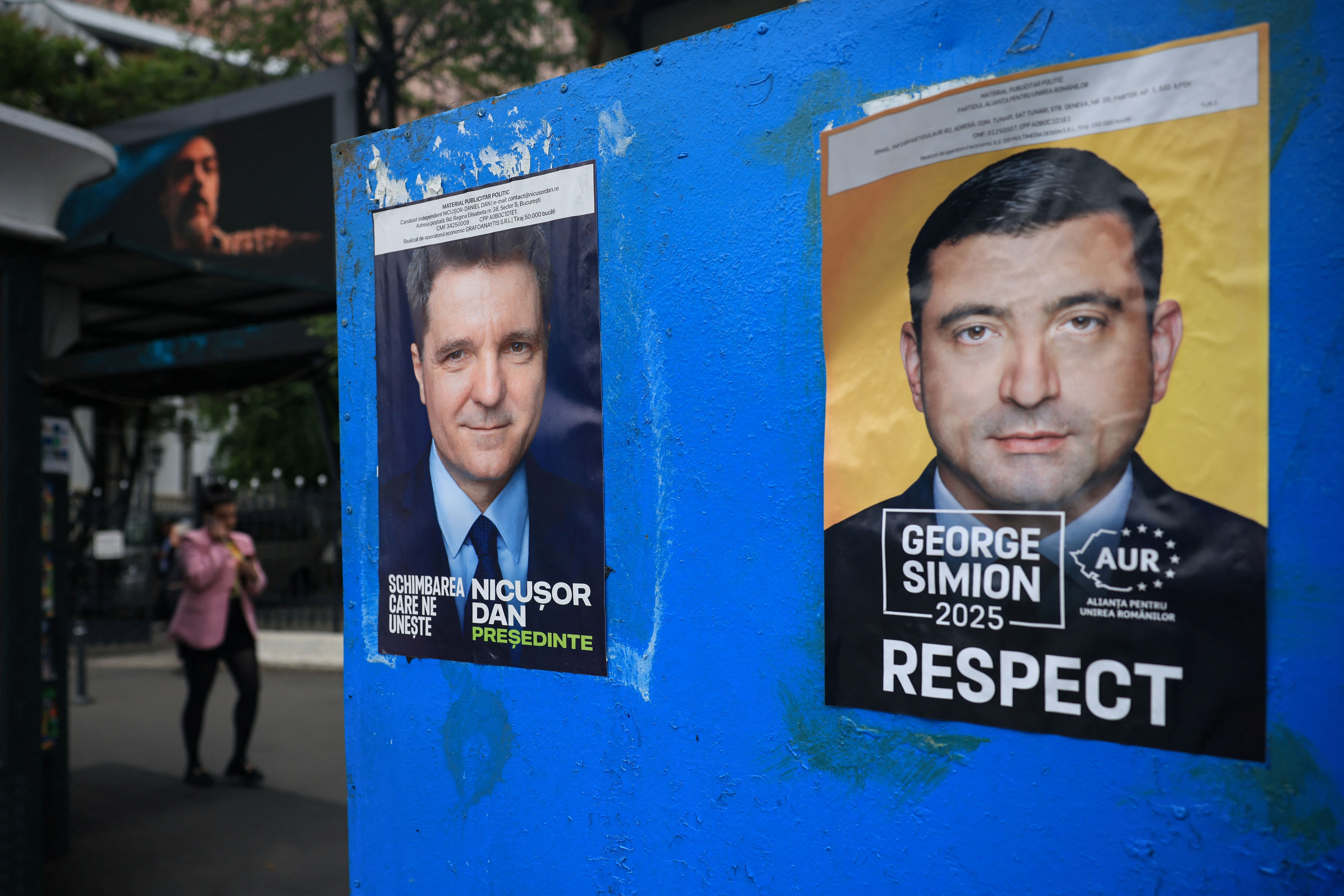 Cartazes dos candidatos Nicusor Dan e George Simion, que disputam segundo turno da eleição presidencial romena