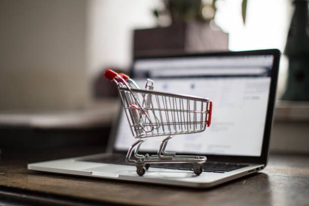 Miniature Shopping Cart on a Notebook with open webpage of a shop