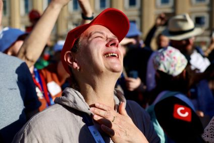 Pessoas reagem enquanto a fumaça branca sobe da chaminé da Capela Sistina, indicando que um novo papa foi eleito no Vaticano, visto de Roma, Itália, em 8 de maio de 2025.