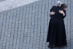 Sacerdotes se abraçam enquanto reagem à fumaça branca que sai da chaminé da Capela Sistina, indicando que um novo papa foi eleito, no Vaticano, em 8 de maio de 2025.