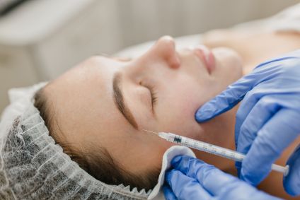 Na imagem, mulher recebe injeção de bioestimuladores de colágeno no rosto.