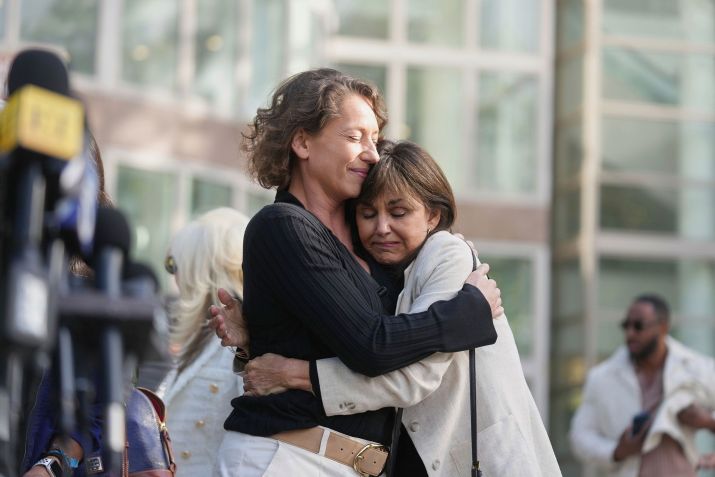 Anamaria Baralt, à esquerda, prima de Erik, e Lyle Menendez, à esquerda, recebe um abraço ao sair do tribunal de Los Angeles após a audiência de nova sentença dos irmãos na terça-feira. • Damian Dovarganes/AP via CNN Newsource