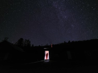 Jiayi Wang fotografou um colega da Universidade de Geociências da China entrando em uma cabana no leste da Sibéria contra o fundo escuro de um céu estrelado