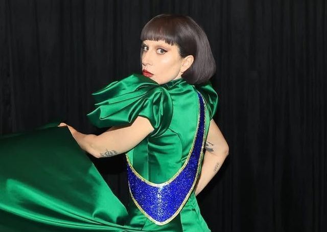 Lady Gaga. Ela é branca, tem o cabelo curto com franja e castanho.