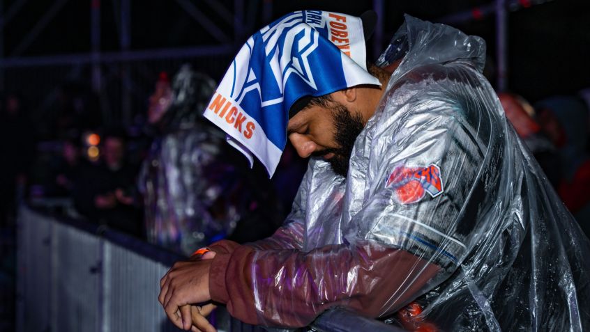 Torcedor do Knicks assiste jogo na chuva • Angelina Katsanis/Getty Images