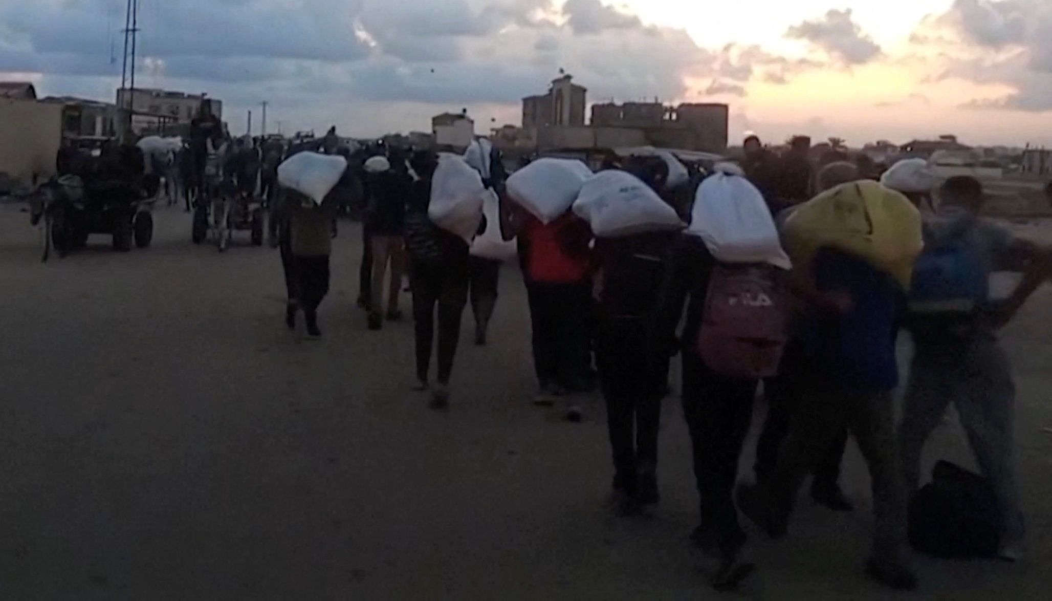 Palestinos carregam ajuda em Rafah, sul de Gaza