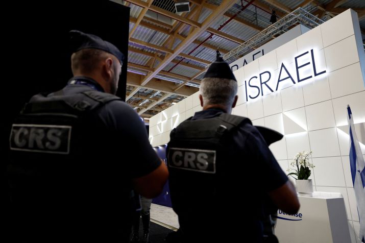 A polícia francesa passa pelo estande do Ministério da Defesa de Israel, que permanece aberto sob proteção, já que os quatro principais estandes de empresas israelenses no Paris Airshow foram fechados pelos organizadores durante o 55º Paris Air Show • Aeroporto Le Bourget, perto de Paris, França, em 16 de junho de 2025 - REUTERS/Benoit Tessier