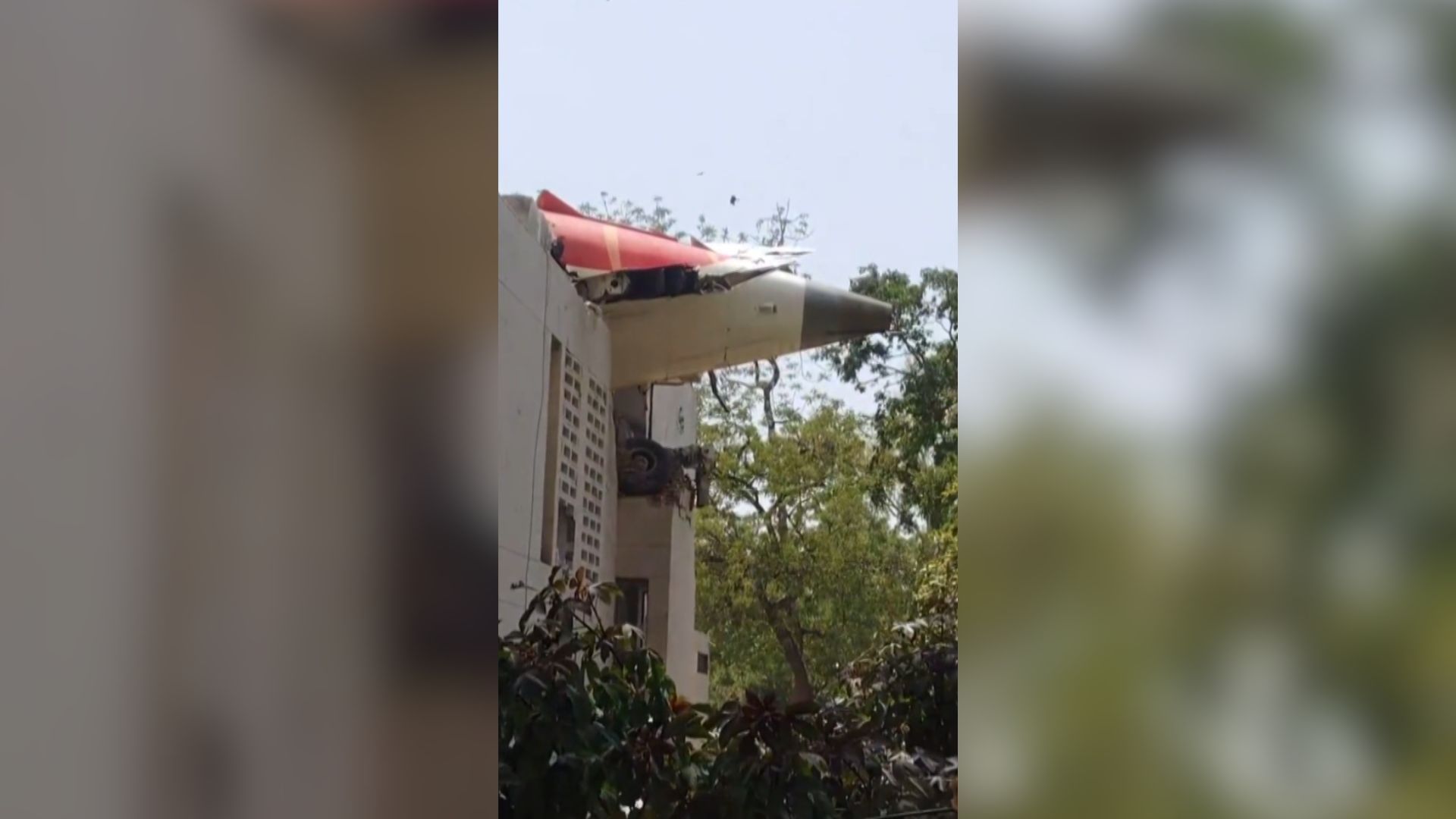 Cauda de avião em cima de prédio após aeronave da Air Índia cair