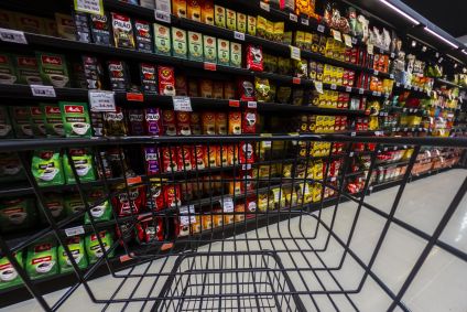 Carrinho vazio parado na frente das prateleiras com diferentes marcas de café e preços diversos no interior de um supermercado na cidade de Marília, no interior de São Paulo