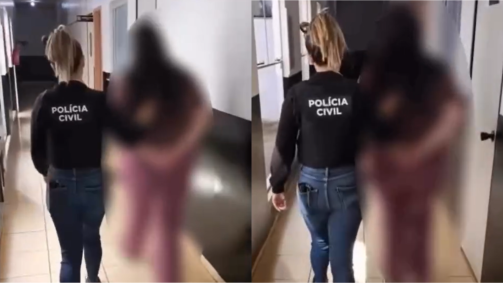 Mulher algemada sendo conduzida por uma agente da polícia