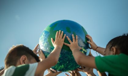 Children holding a planet outdoors